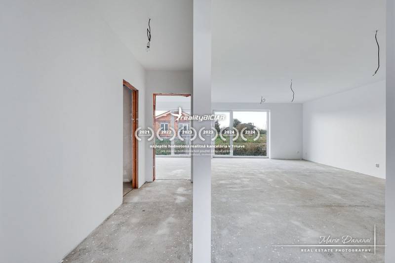 An empty interior in a family house with a view of a large window and an entrance area.
