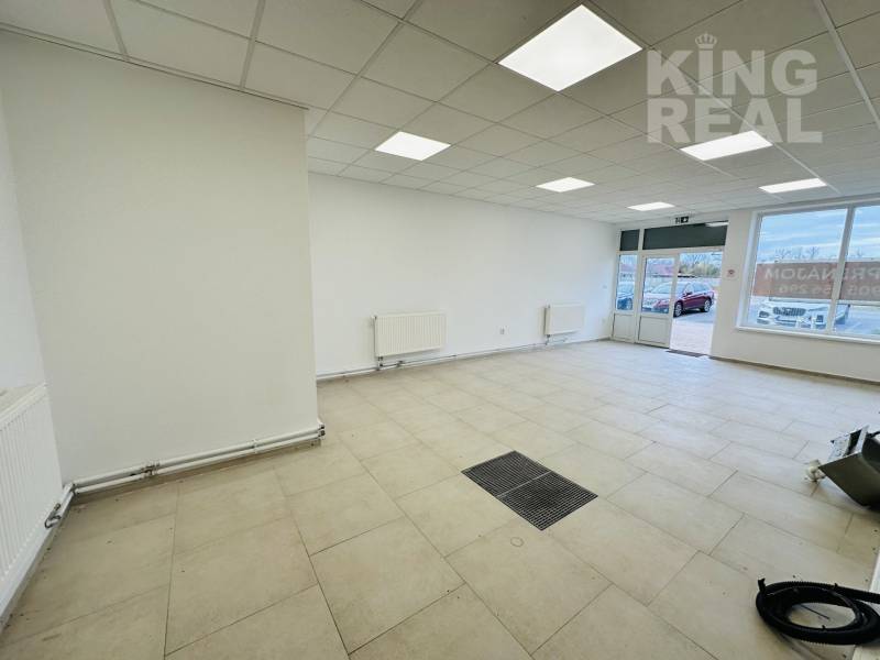 Commercial space with tiles, white walls, and a large window.