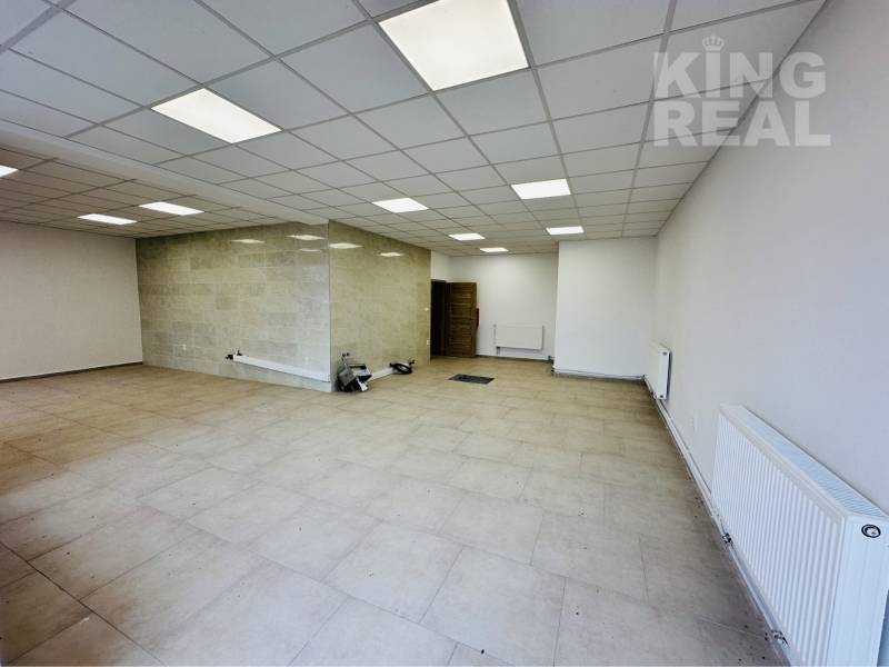 Commercial spaces with white walls, tiles, and modern ceiling panels.