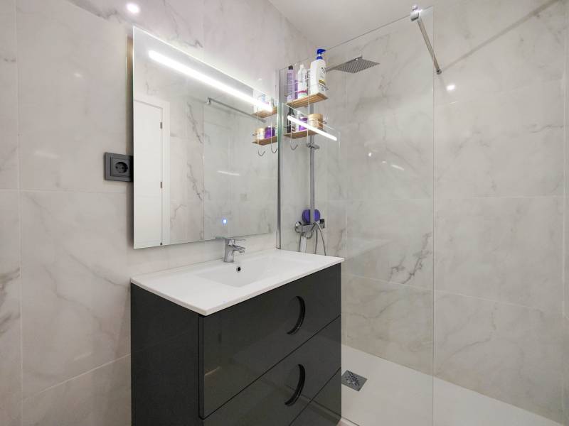 Bathroom in a 3-room apartment with white tiles and a shower corner.