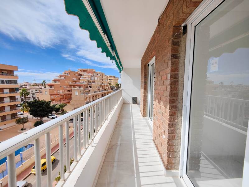 Balcony of a 3-bedroom apartment on Calle Arrecife t, Punta Prima with a street view.
