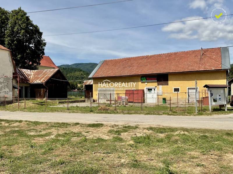 A building in Jasení with a red roof and a fenced plot.