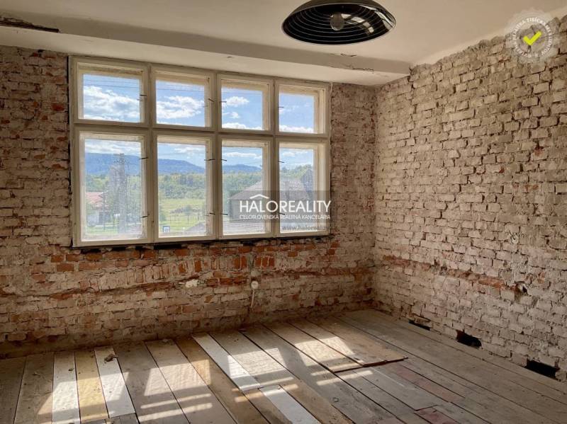 A room with brick walls and a wood-patterned floor in a family house.