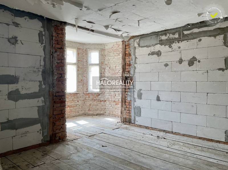 Interior of a family house with exposed brick walls and a wood-patterned floor.