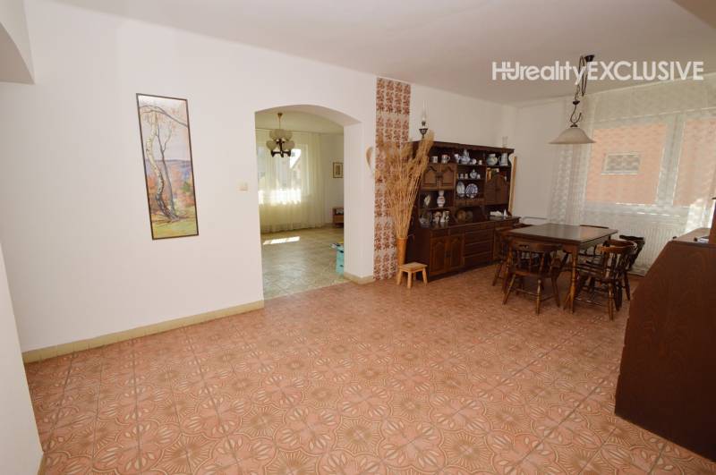 Dining room in a family house with patterned flooring and wooden furniture.