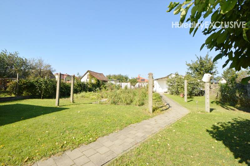 Garden area with lawn in a family house in Hegyeshalom, with a concrete walkway.