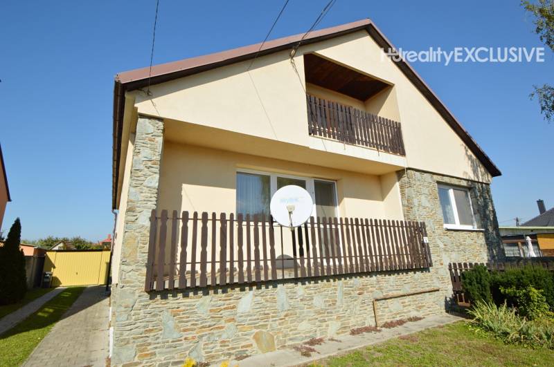 A family house in Hegyeshalom with a balcony, satellite, and stone cladding on the facade.