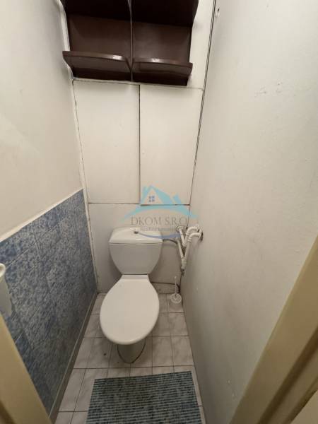 A bathroom with a standing bowl and blue tiles in a two-room apartment.