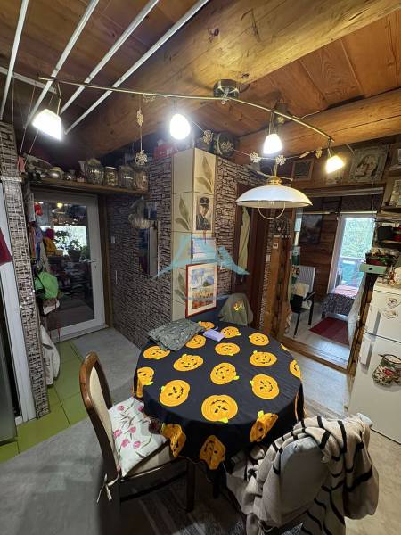 A cottage with a dining table and Christmas decorations, wooden decor of the ceiling and walls.