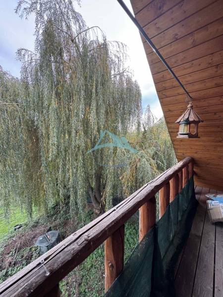 A balcony at a cottage in Dolné Rykynčice with a view of greenery and wooden decor.