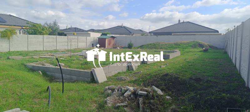 A plot for residential use in the Mládežnícka district in Galanta, surrounding houses and vegetation.