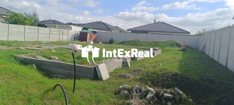 A residential plot in the Youth District of Galanta with a green area and a fence.
