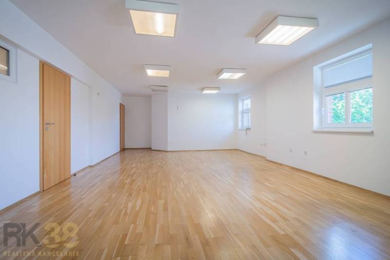 The interior of a building with a spiral staircase and upholstered carpet, railing, and wooden doors.