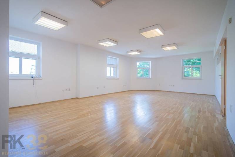 Building on Halatova Street in Poprad with a parking lot and a view of the mountains.