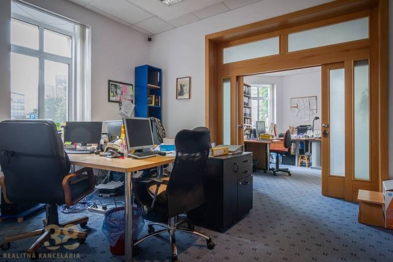 Classroom in a building, with carpeted flooring and storage furniture.