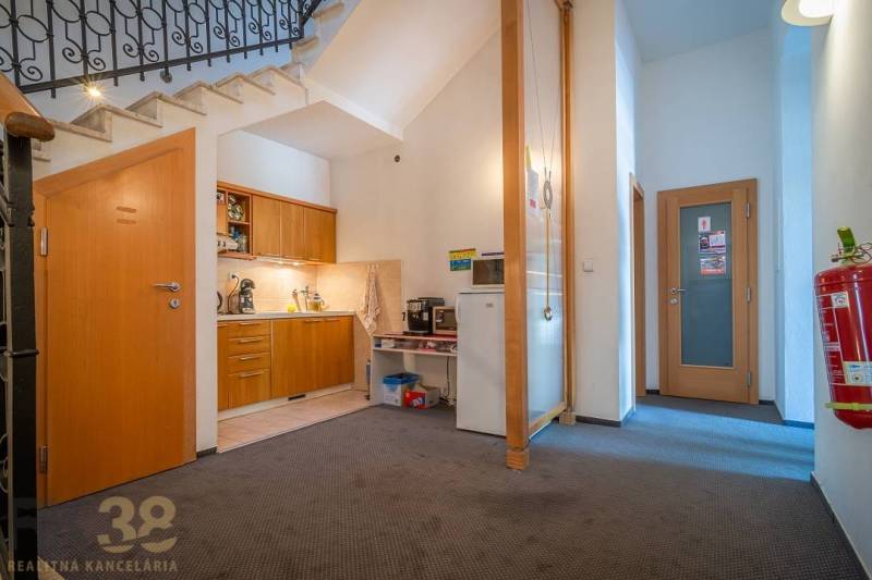 Meeting room with a round table, blue chairs, and abstract art on the walls.