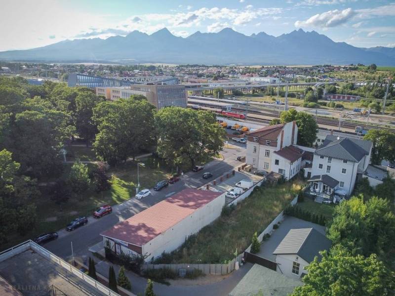 Building on Halatova Street in Poprad with advertising banners and an adjacent residential structure.