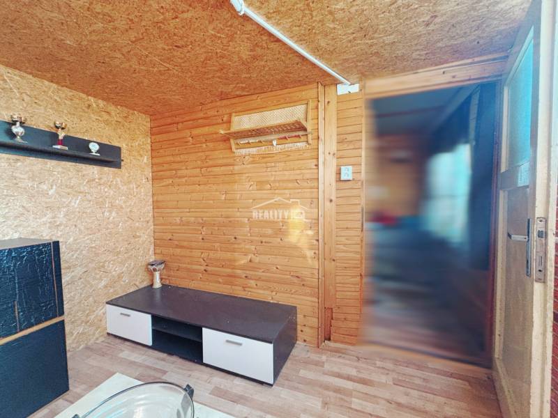 Wooden interior with a shelf and a table on the floor with a wooden decor in the Gardens.