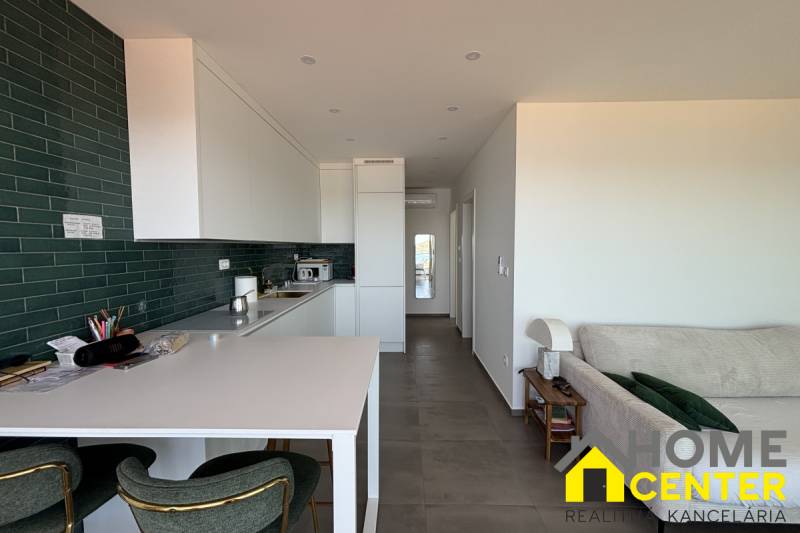 The kitchen of the villa with green tiles and a counter, combined with a relaxation area.