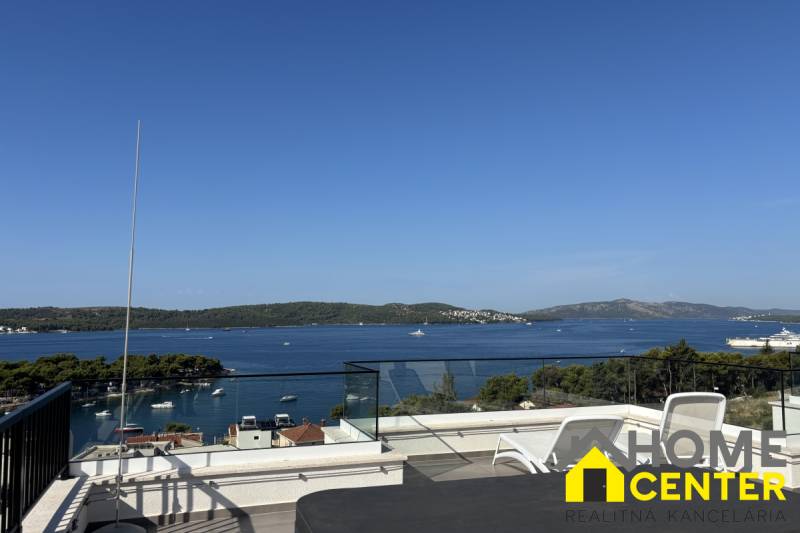 Sea view from the villa in Trogir. Terrace with loungers and glass railing.