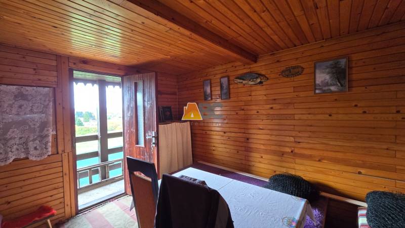 The interior of a wooden cabin with doors to the terrace and decorations on the walls in the gardens.