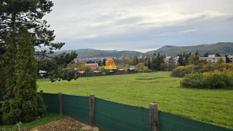 Gardens in Zvolen on A. Hlinka Street with a view of the hills and houses.