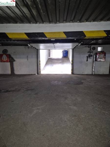 Interior of a garage with an exit, stone-patterned floor, light on Medená in Bratislava.