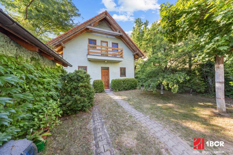 A family house on Senecká Street in Pezinok surrounded by greenery and a sidewalk.