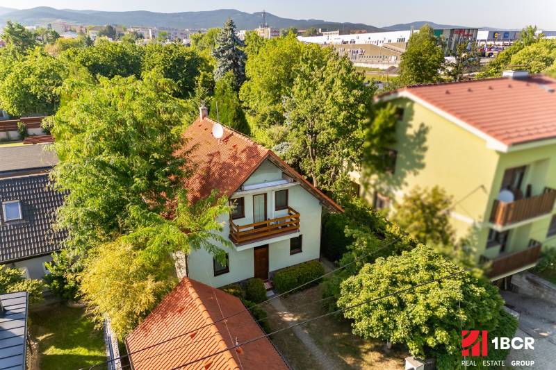 A family house on Senecká Street in Pezinok surrounded by greenery and neighboring buildings.
