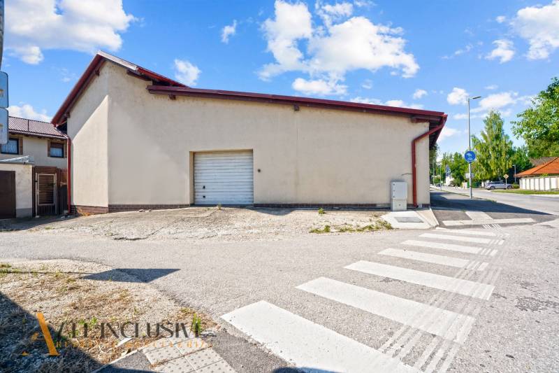 Commercial premises in Dunajská Streda with garage doors and an adjacent sidewalk.