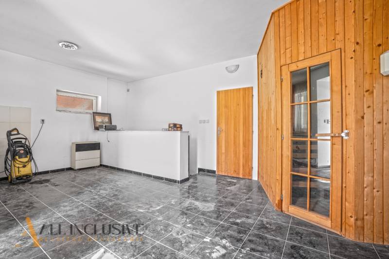 Interior of commercial spaces with white walls, black tiles, and wooden doors.