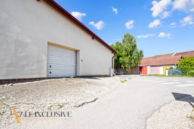 Paved area with a garage in commercial premises in Dunajská Streda on a sunny day.