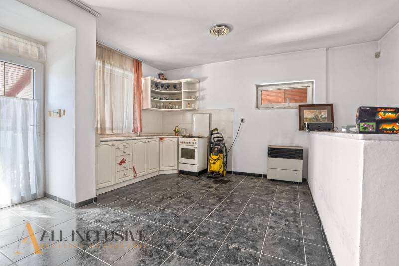Interior of a kitchen with a corner unit and black tiles in commercial premises.