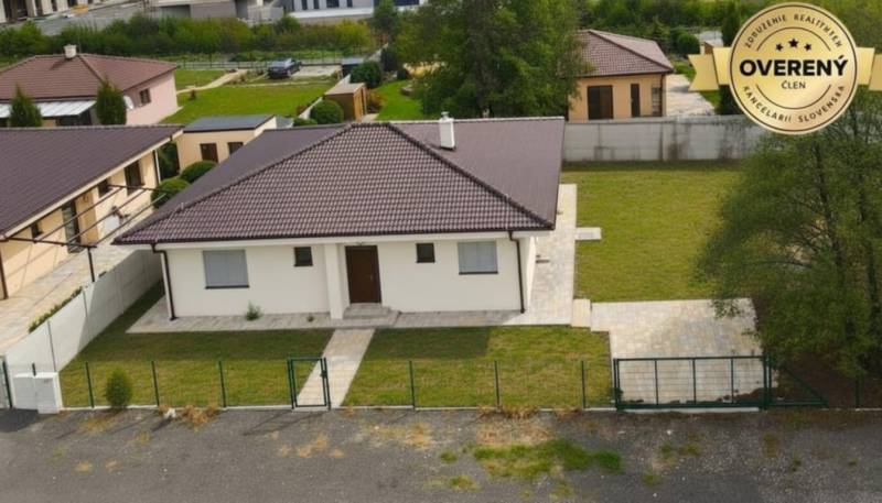 A family house in Studienka with a garden, a paved walkway, and a brown roof.