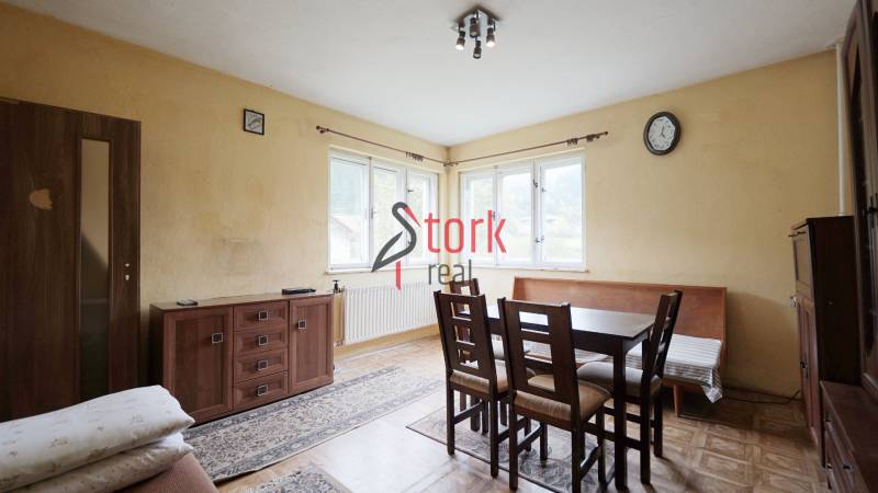 Dining room in a family house with a wood-patterned floor and a large window.