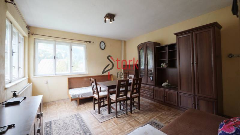 A living room in a family house with light furniture and a wooden decor floor.