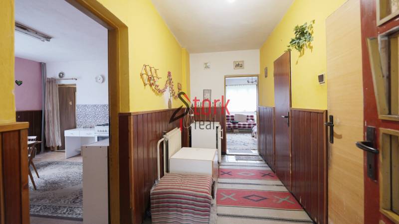 A hallway in a family house with wooden paneling and colorful walls.