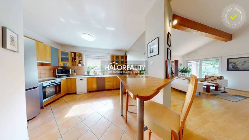 Kitchen and living room with wood-patterned flooring in a family house.