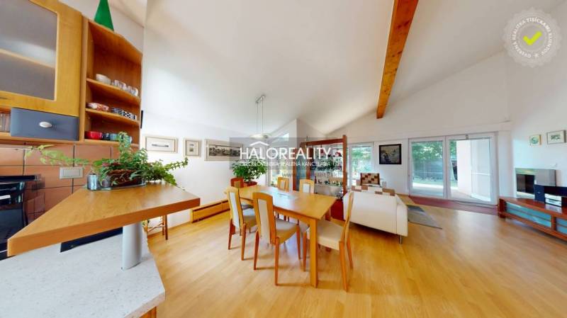 Dining room with a large table and a wooden decor floor in a family house.