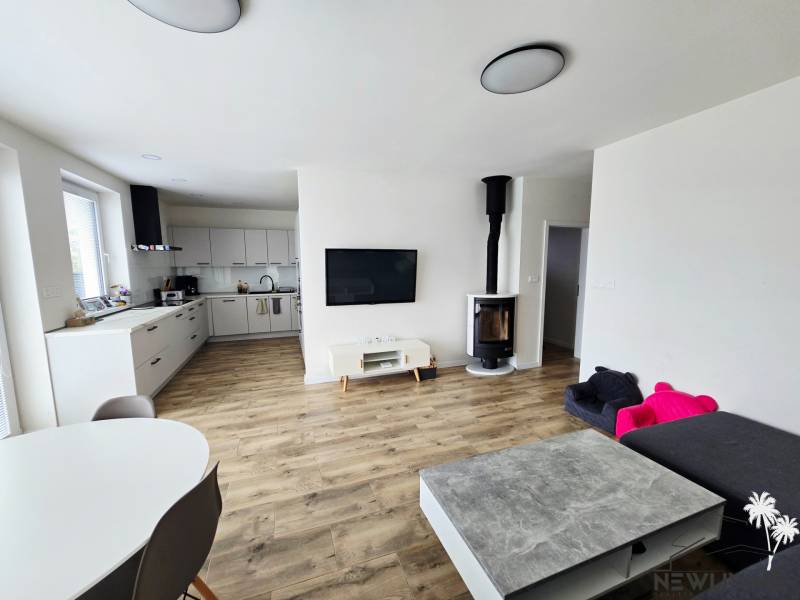 Living room in a family house with a kitchenette and a wooden decor floor.
