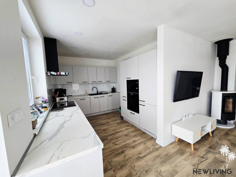 The kitchen and living area of the family house with a wooden decor floor.