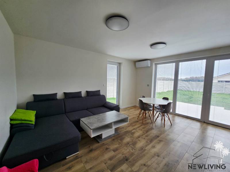 Living room in a family house with a sofa, table, and wooden decor flooring.