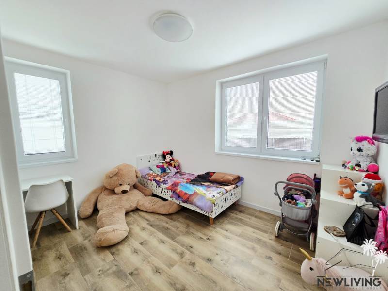 Children's room with a bed, a desk, and a floor with a wooden decor in a family house.