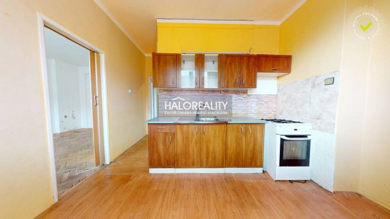 A room in a 2-room apartment with a wooden decor floor and large windows.
