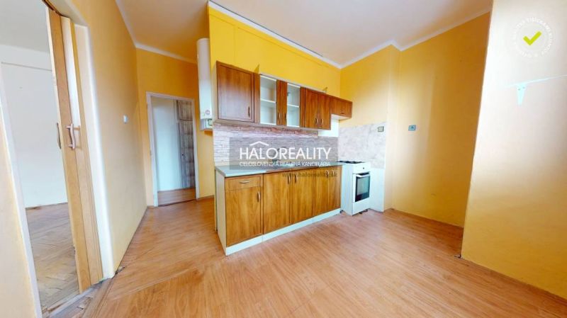 A kitchen unit in a 2-room apartment with a wooden decor floor.