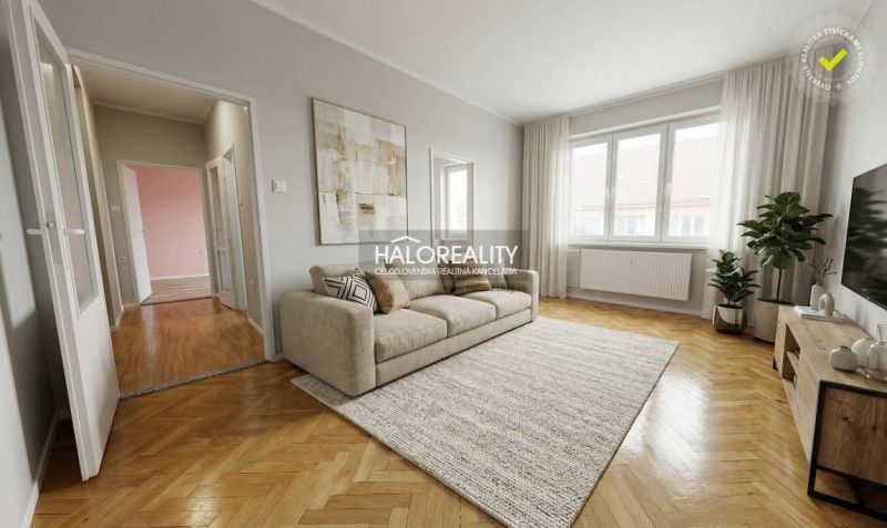 A room with a wooden decor floor in a two-room apartment, light walls, large window.