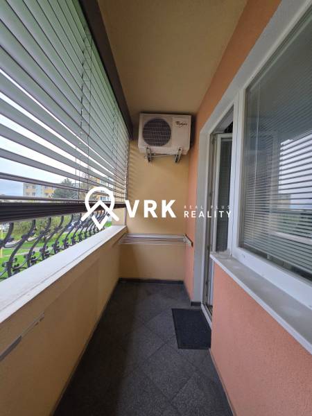 A balcony with blinds and air conditioning in a 1-room apartment.