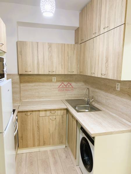 A kitchen unit in a 3-room apartment with a wooden decor and built-in appliances.