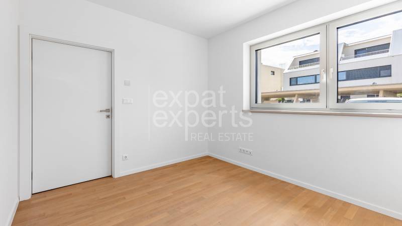 A room in a 4-room apartment with a wooden decor floor and a large window.