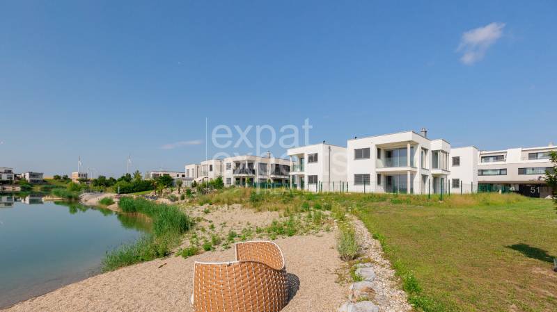 A lakeside 4-room apartment in Kittsee, Am Seepark, with modern buildings by the lake.